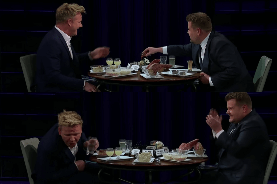 This image shows a scene from the "Spill Your Guts or Fill Your Guts" segment on The Late Late Show with James Corden. In this game, host James Corden and guest chef Gordon Ramsay sit across from each other with a table full of unappealing or bizarre food items labeled with names like "clam juice" and "salmon ice cream." In the top part of the image, Corden offers Ramsay a particularly unappetizing item. In the lower part, Ramsay reacts dramatically, clutching a glass of water, while Corden laughs and claps at his discomfort.