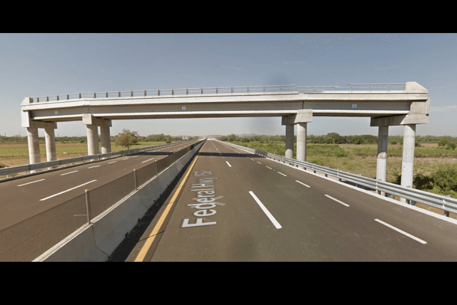 This image shows a view of a wide, multi-lane highway (labeled Federal Hwy 15) with an overpass crossing above it. The overpass is unfinished, leading to nowhere.