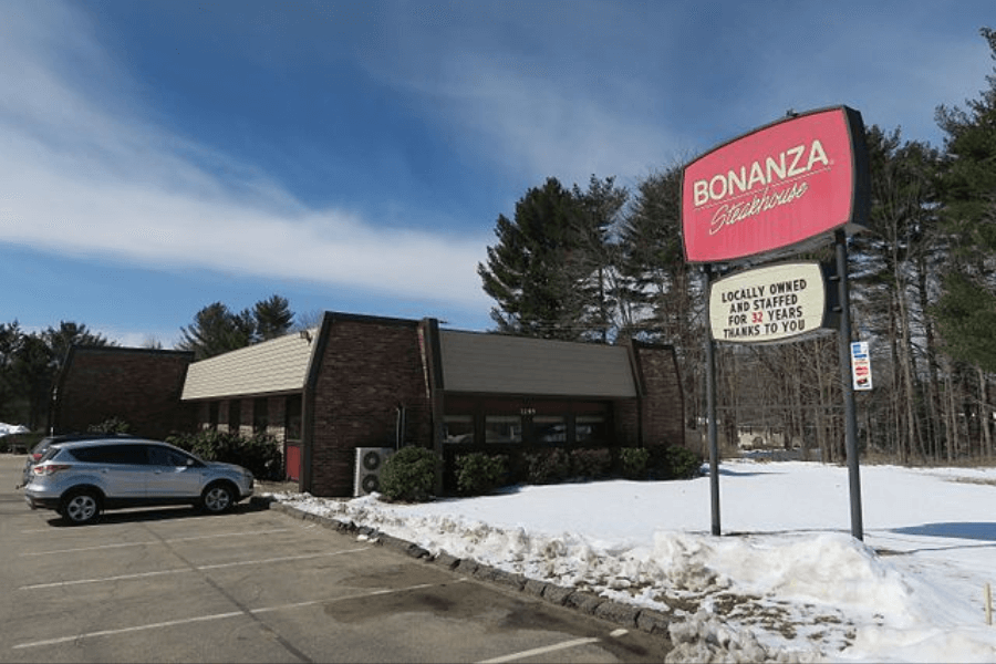 The image shows a Bonanza Steakhouse with its signature red sign, located in a snowy parking lot. The sign highlights, "Locally owned and staffed for 32 years—thanks to you," showcasing its community roots.