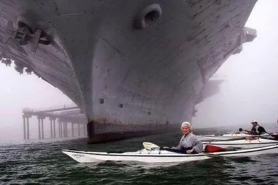 gigantic ship next to a woman on a boat