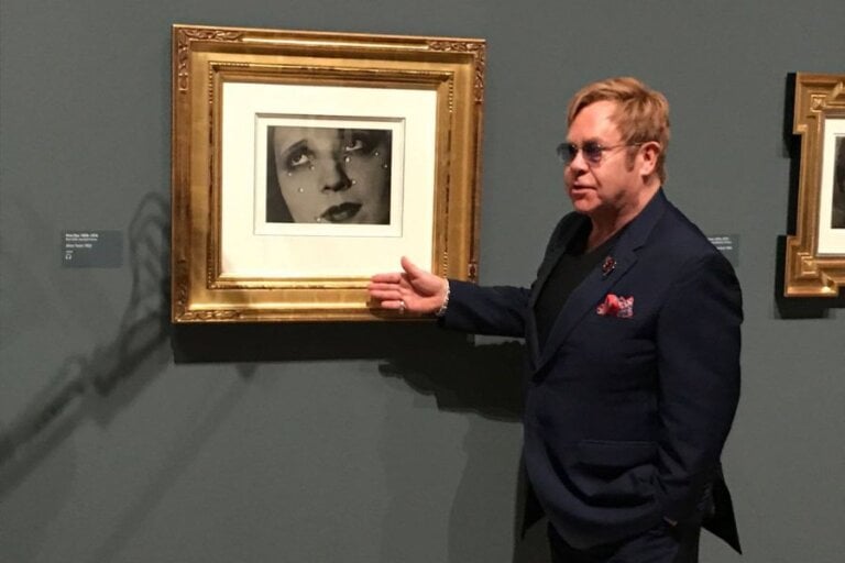 Elton John standing next to a picture