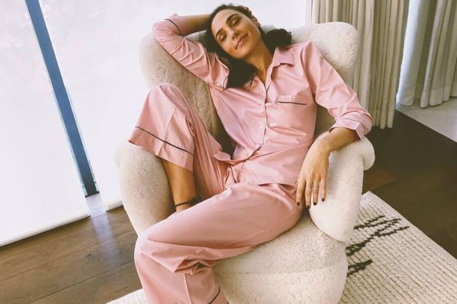 Gal gadot sitting on a couch in her pjs