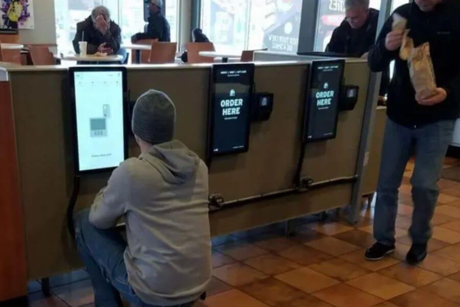 Man ordering food on a screen that is badly installed