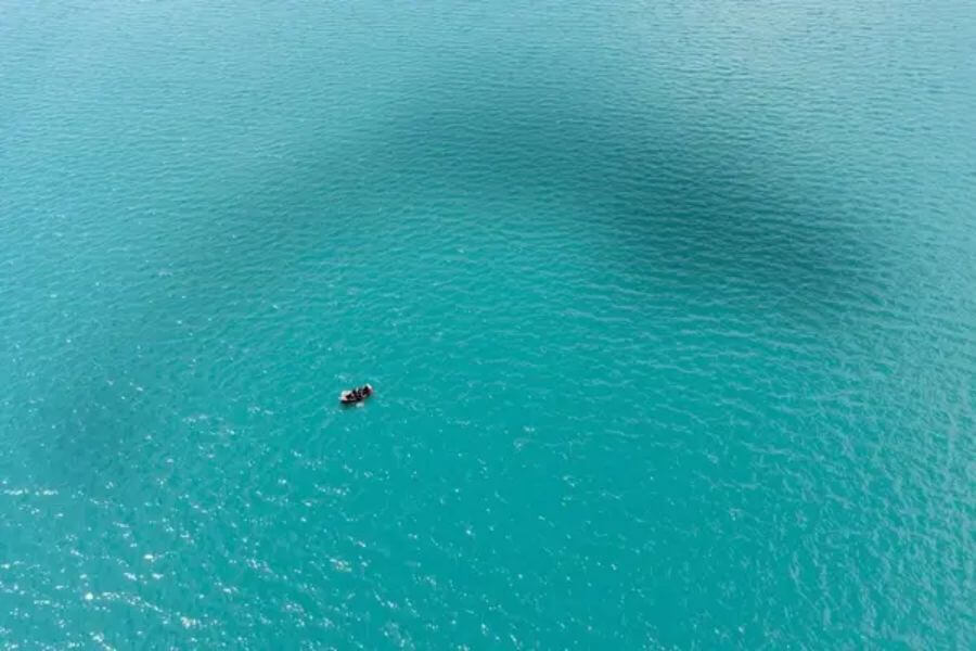 tiny boat in the middle of the ocean