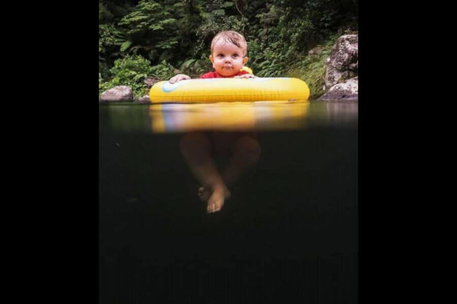 little kid floating on a pond