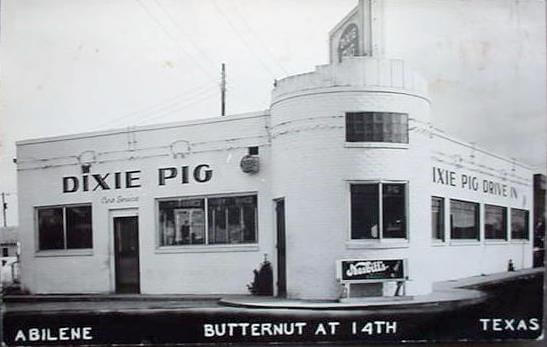A vintage black-and-white photograph of the Dixie Pig Drive-In restaurant, located at Butternut and 14th in Abilene, Texas. The building has a distinctive rounded corner tower and large windows, with signage displaying "Dixie Pig" and "Curb Service." A small sign near the entrance advertises "Jax Beer," adding to the classic mid-20th-century diner aesthetic.