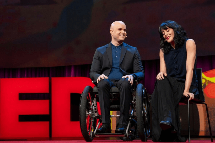 man in a wheelchair in a TED background