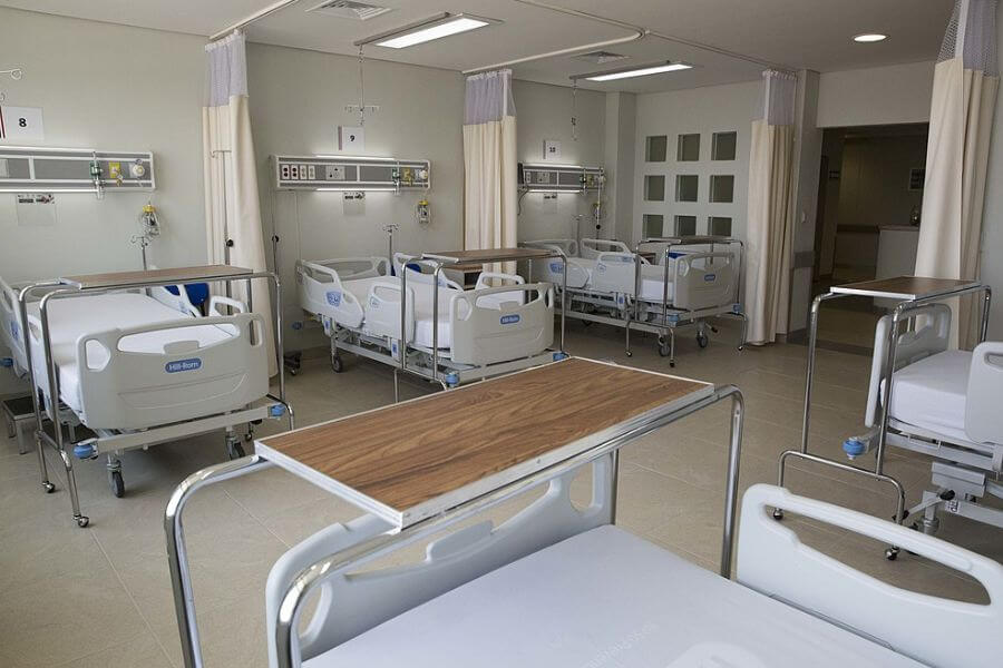 lots of beds in an empty hospital room 