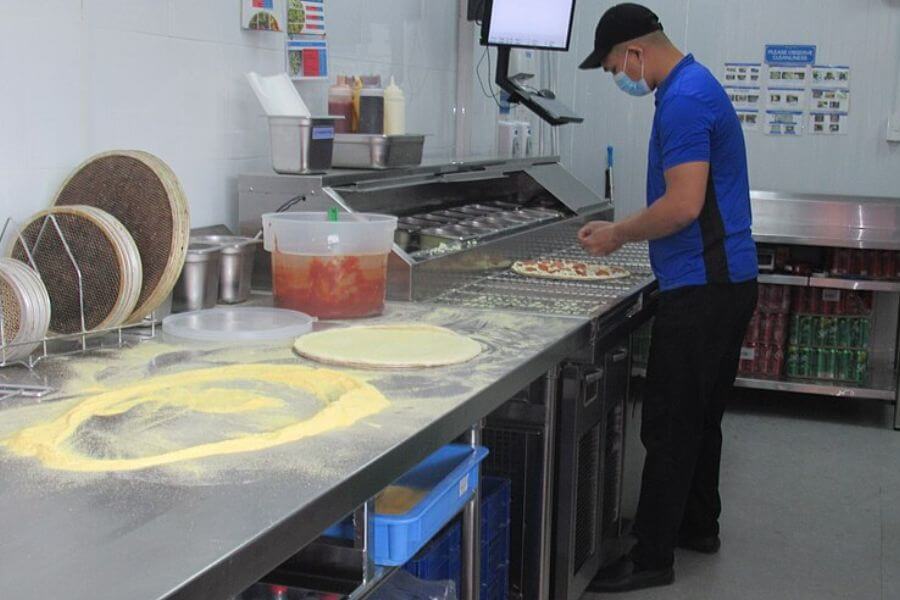 domino's employee cooking in the kitchen