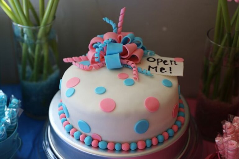 white frosting cake with blue and pink dots