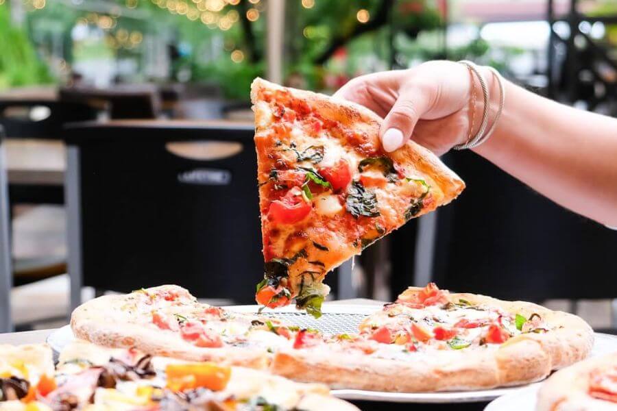 hand holding pizza