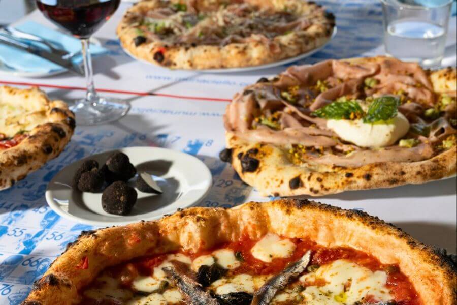 several pizzas on top of table