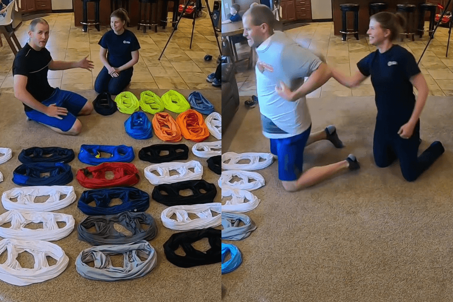 The image shows a split view of a fun and competitive activity involving two people and a collection of colorful T-shirts. On the left, the participants are seated on the floor with neatly arranged T-shirts in various colors laid out before them, possibly preparing for a challenge. On the right, the man is in the process of putting on multiple T-shirts while the woman assists him, both appearing engaged and amused. The indoor, casual setting suggests this is a playful attempt at a record or challenge involving the most T-shirts worn.