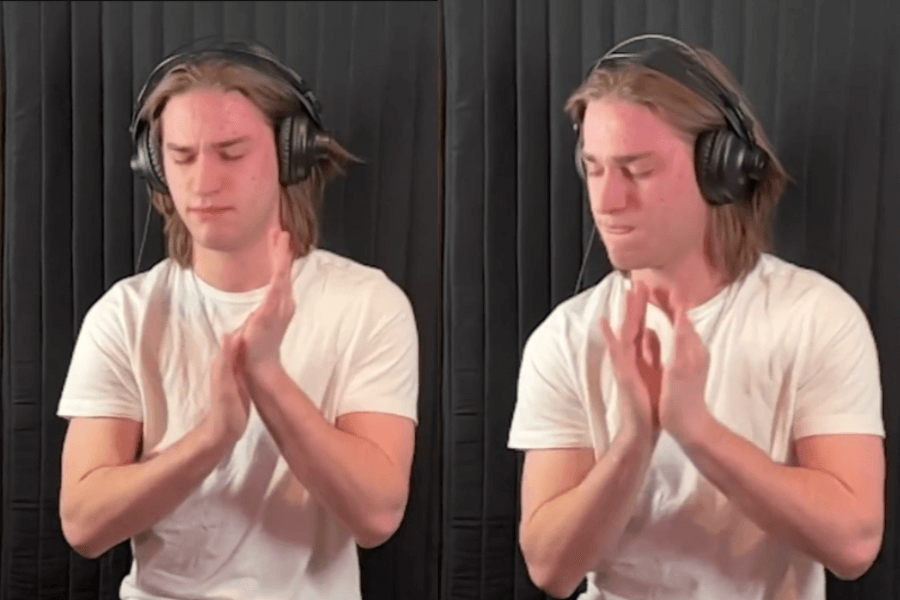 The image features a young man wearing a white shirt and headphones, focusing intensely as he claps his hands in rapid motion. The backdrop is a plain, dark curtain, likely in a soundproofed or studio-like environment. The scene suggests he is attempting a clapping-related challenge, potentially for speed or quantity, as part of a personal achievement or record-breaking event.