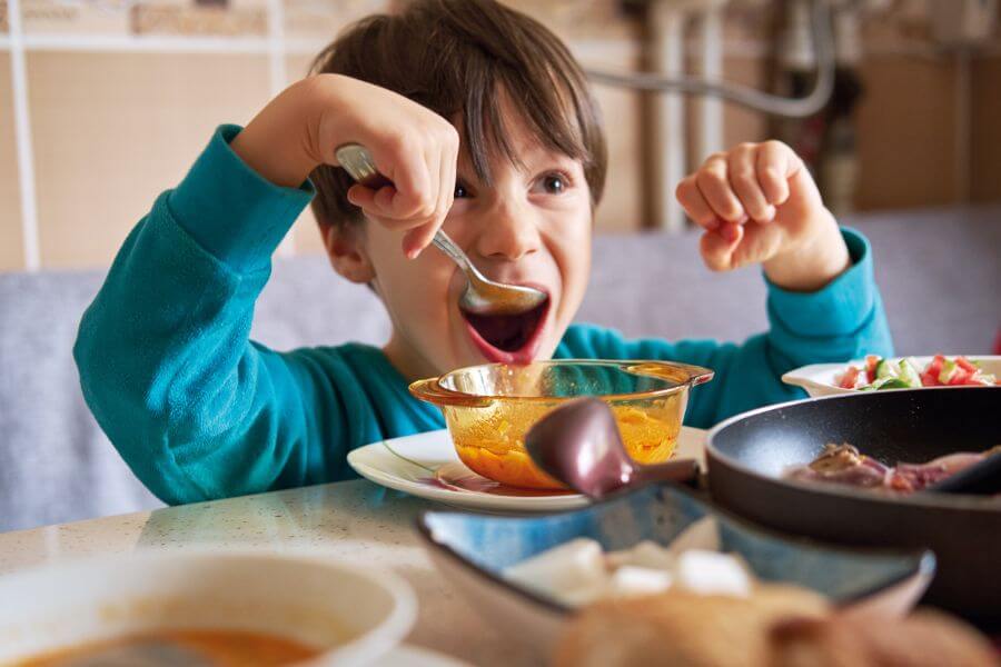 4-5 years old cute child eating soup