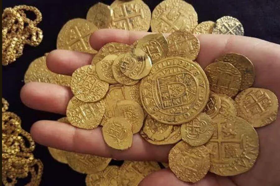 Hand holding ancient golden peruvian coins