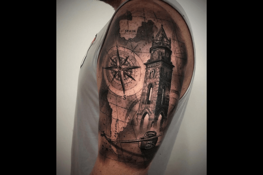 A tattoo featuring a vintage map with a compass rose, a detailed clock tower, and nautical elements like ropes and anchors. The design blends exploration and history seamlessly.