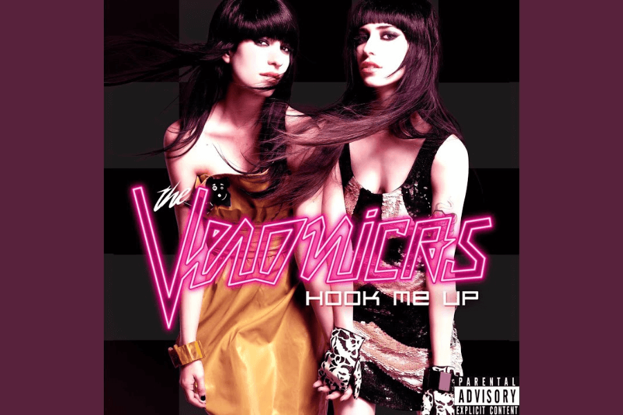 Album cover for Hook Me Up by The Veronicas, featuring two women with long dark hair wearing stylish gold and black outfits. They pose against a black and gray checkered background with wind-blown hair, giving the image a dynamic, edgy feel. The album title and band name are displayed in bold neon pink text, with a "Parental Advisory" label in the bottom right corner.