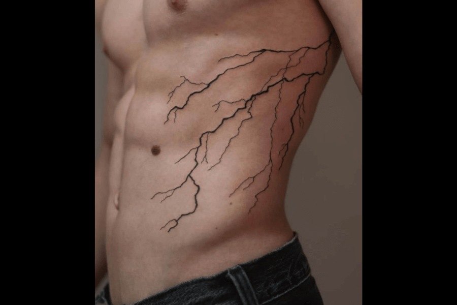 A minimalist tattoo of lightning bolts branching across the ribcage. The design is simple, with thin, jagged lines mimicking the natural pattern of electricity.