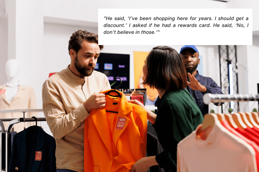 This image shows a man holding an orange jacket with a discount tag while speaking to a woman in a green shirt inside a clothing store. The background includes racks of clothes and another employee observing the conversation. The quote in the image reads: "He said, ‘I’ve been shopping here for years. I should get a discount.’ I asked if he had a rewards card. He said, ‘No, I don’t believe in those.’"