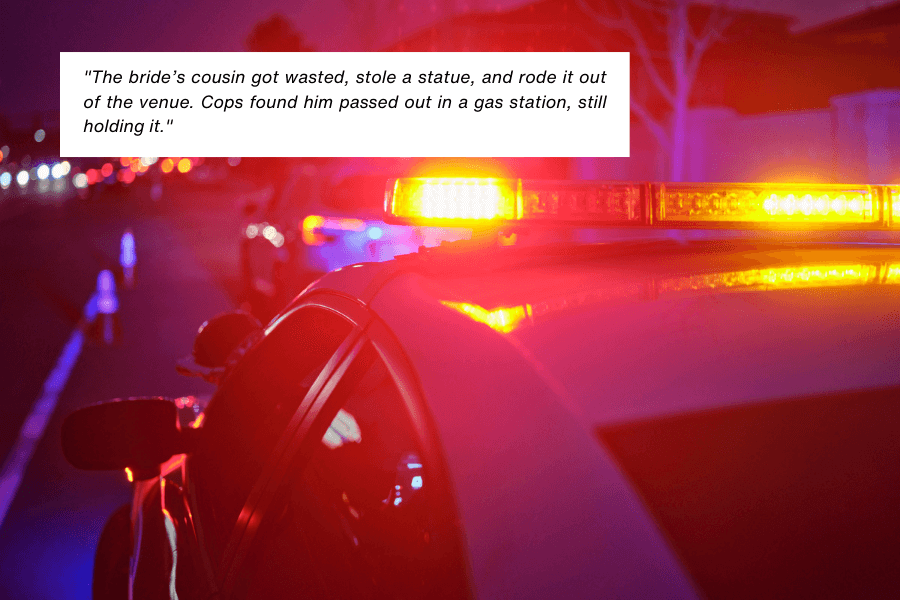 A police car with flashing lights is parked on a street at night, with blurred vehicles in the background. A caption narrates an unusual incident where the bride’s cousin got drunk, stole a statue, rode it out of the venue, and was later found passed out at a gas station still holding the statue.