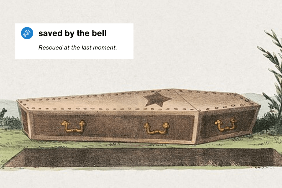 A vintage illustration of a coffin with gold handles, placed beside a freshly dug grave. The coffin has a bell mechanism attached, referencing historical safety coffins designed to prevent premature burial. A text overlay in the top left corner reads: "Saved by the bell – Rescued at the last moment."