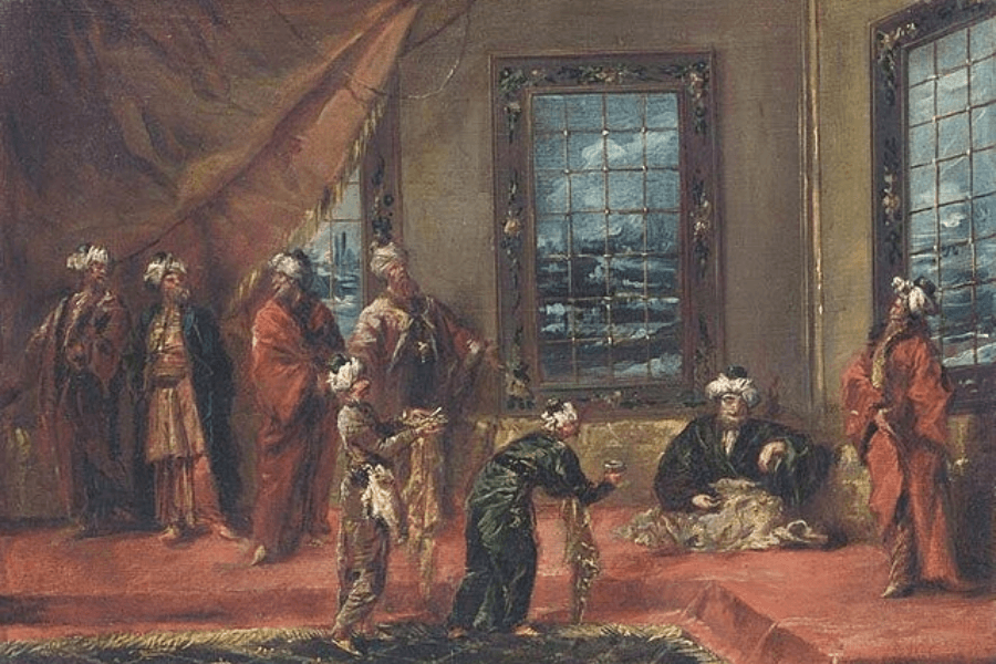 A richly detailed oil painting depicting an opulent palace interior with figures dressed in luxurious, flowing garments and turbans, evoking an Ottoman or Eastern court setting. The scene is filled with courtiers, attendants, and a seated noble figure, possibly a sultan, receiving offerings from kneeling servants. Large windows in the background reveal a view of a vast landscape, while warm lighting and intricate textiles enhance the regal atmosphere.