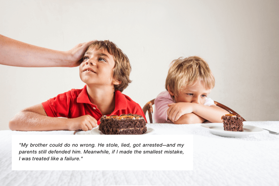 A young boy in a red shirt smiles while being affectionately patted on the head by an unseen adult hand, sitting in front of a large slice of chocolate cake. Next to him, another boy in a pink shirt looks sad and leans on the table, facing a smaller slice of cake. Below the image, text reads: "My brother could do no wrong. He stole, lied, got arrested—and my parents still defended him. Meanwhile, if I made the smallest mistake, I was treated like a failure."