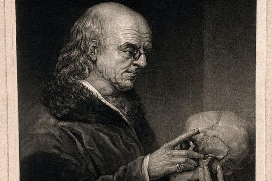 A black-and-white engraving of an elderly, scholarly man with thinning hair, wearing glasses and a fur-collared coat, as he carefully examines a human skull. His intense expression and the way he points at the skull suggest a deep focus, possibly in a medical or philosophical context. The dark background enhances the dramatic lighting, evoking themes of anatomy, mortality, or scientific inquiry.