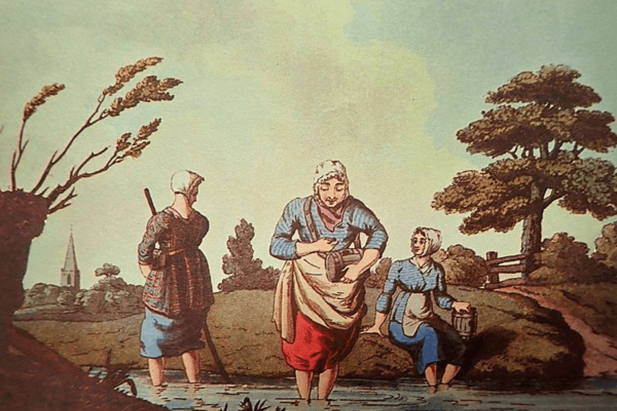 A vintage illustration depicting three women in traditional rural attire gathering water from a small stream. One woman stands in the water holding a wooden pail, another sits on the bank dipping her feet while holding a bucket, and the third stands with her back turned, gazing into the distance with a staff. The landscape features rolling hills, trees, and a distant church steeple, evoking a peaceful countryside scene.