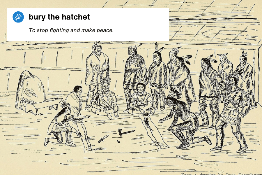 A historical black-and-white illustration depicting a group of Indigenous people gathered inside a longhouse, with two individuals ceremonially burying a hatchet in the ground. A text overlay in the top left corner reads: "Bury the hatchet – To stop fighting and make peace."