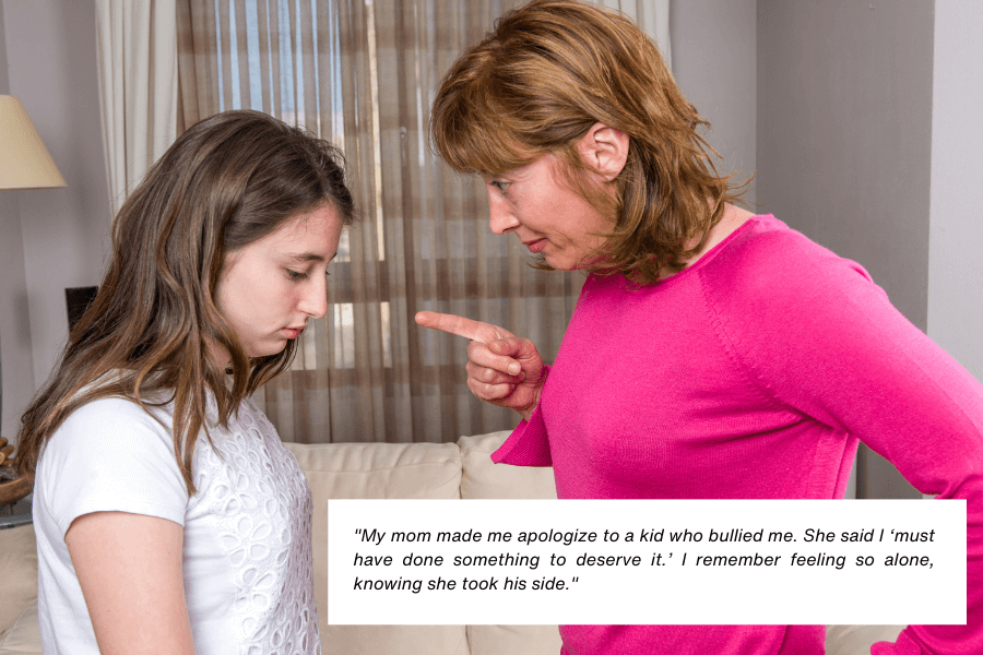 A teenage girl wearing a white shirt looks down sadly as a woman in a bright pink top points her finger at her in a reprimanding manner. The two stand in a living room with a beige couch and a lamp in the background. Below the image, text reads: "My mom made me apologize to a kid who bullied me. She said I ‘must have done something to deserve it.’ I remember feeling so alone, knowing she took his side."