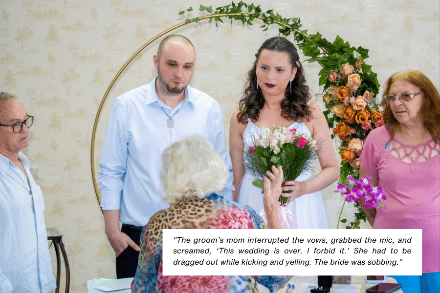 A bride holding a bouquet and a groom stand at their wedding ceremony with a visibly tense atmosphere as an older woman speaks dramatically, surrounded by family members. A caption explains that the groom’s mother interrupted the vows, declaring the wedding over, and had to be removed as the bride cried.