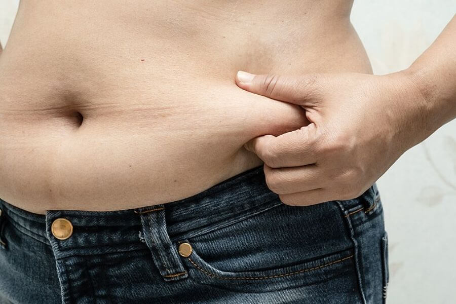 female body fat. hand grabbing belly