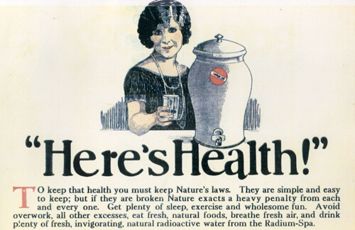 A vintage advertisement featuring a smiling woman holding a glass of water next to a large ceramic dispenser. The bold text reads 'Here's Health!' and the ad promotes drinking 'invigorating, natural radioactive water' from the Radium-Spa. The text encourages a healthy lifestyle while endorsing radium-laced water as a wellness product, reflecting early 20th-century misconceptions about radiation.