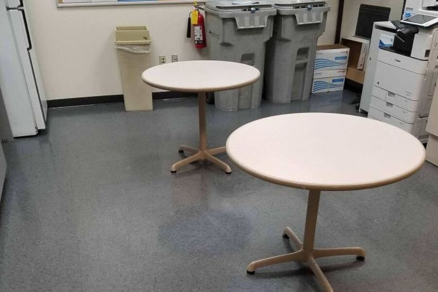 two office tables with no chairs in an empty room 