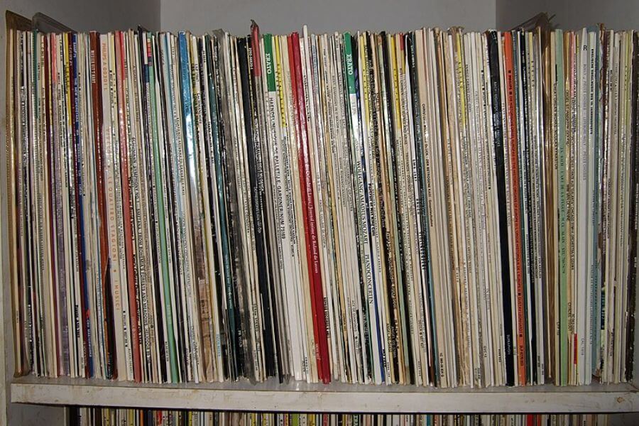 The photograph shows a tightly packed shelf filled with an eclectic collection of vinyl records. Their colorful spines create a chaotic yet mesmerizing display of music history. Each record holds the promise of crackling nostalgia, transporting listeners to a different era with every spin. From classic rock to obscure jazz, this collection is a testament to the timeless magic of analog sound.