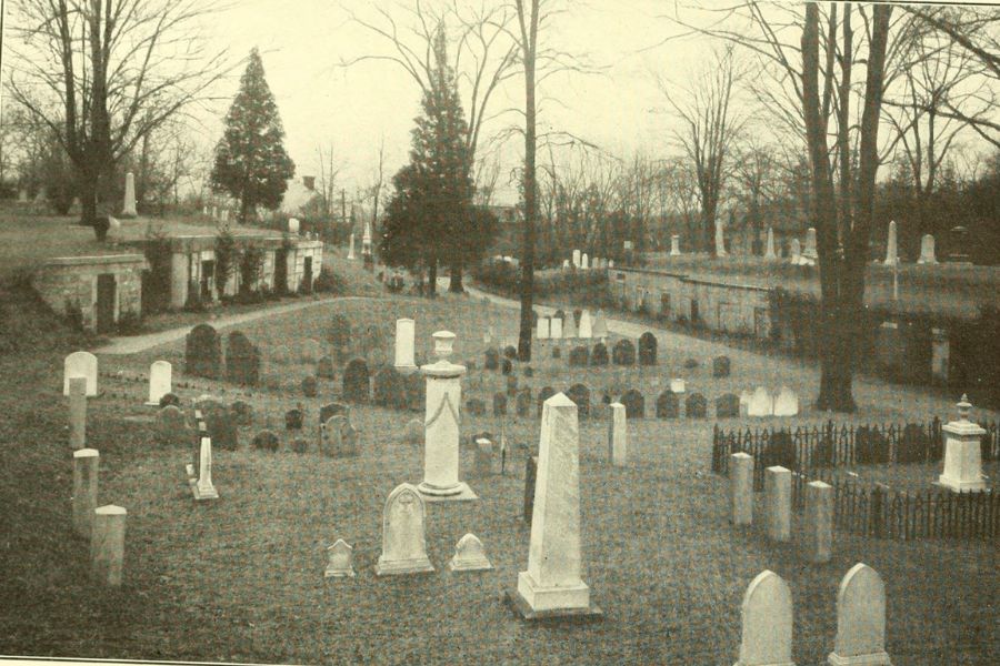 A black and white historical photograph of Walnut Street Cemetery, showing a landscape filled with gravestones, monuments, and mausoleums. The scene features leafless trees, pathways, and rows of burial sites, creating a solemn and serene atmosphere. The image appears to be from an old book or archival source.