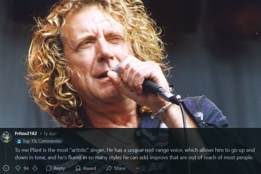  A male rock singer with curly blonde hair passionately performs on stage, gripping a microphone close to his mouth. He wears a loose, patterned shirt with a deep neckline, accessorized with a silver bracelet and a pendant necklace. His intense facial expression and slightly squinting eyes capture the raw energy of the performance.