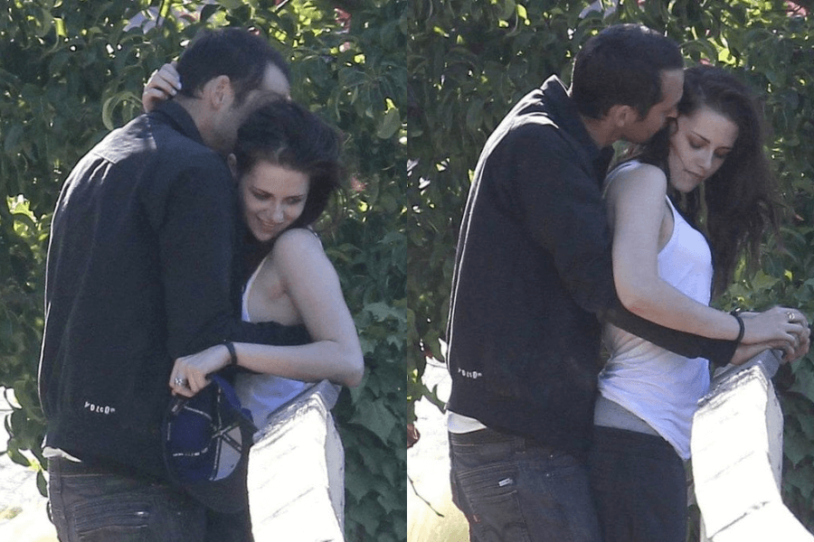 A side-by-side collage of two candid outdoor photos captures a man and a woman in an intimate moment. In the left image, the man, dressed in a dark jacket, leans in to kiss the woman's head while she smiles and holds a cap. In the right image, the man embraces the woman from behind, kissing her temple as she looks downward with a neutral expression. The setting is lush with greenery, and the lighting suggests a bright day.