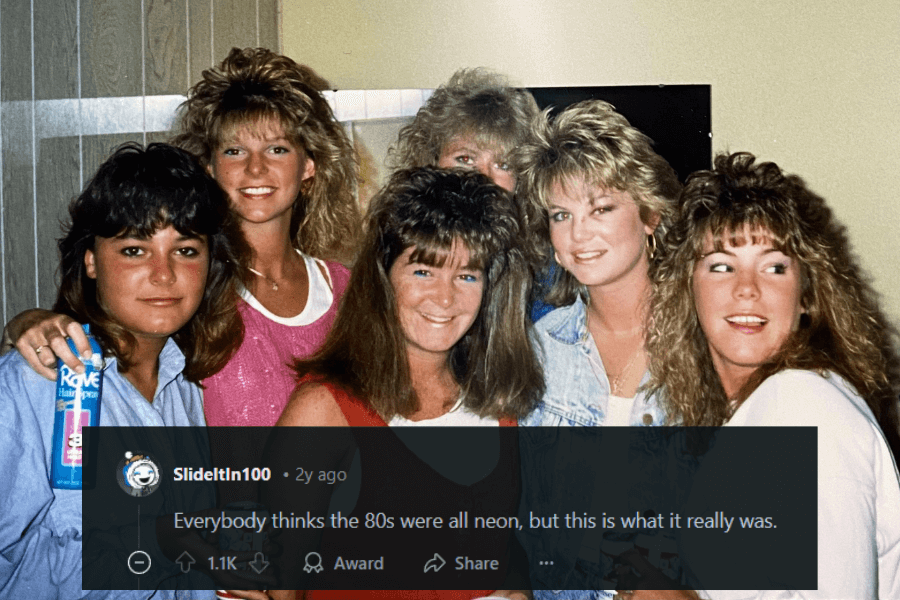 A group of six young women pose together in a classic 1980s setting, all sporting voluminous, teased hairstyles with heavy bangs. They are dressed in casual outfits, with denim jackets, tank tops, and bold accessories. One woman in the foreground holds a can of Rave hairspray, a staple of 80s styling. A caption humorously comments on how the real 80s aesthetic wasn’t just neon but heavily styled hair and lots of hairspray.