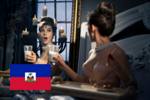 A glamorous woman in vintage-style lingerie and pearl jewelry looks shocked at her reflection while holding a glass of milk, with candlelight casting a dramatic glow in a luxurious bedroom. The Haitian flag is displayed in the bottom left corner of the image.