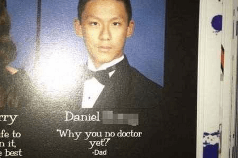  A high school yearbook photo of Daniel [last name blurred], a young man wearing a black tuxedo and bow tie, looking serious at the camera against a blue backdrop. Below his name, his humorous yearbook quote reads, "Why you no doctor yet?" — Dad, playfully referencing high parental expectations.