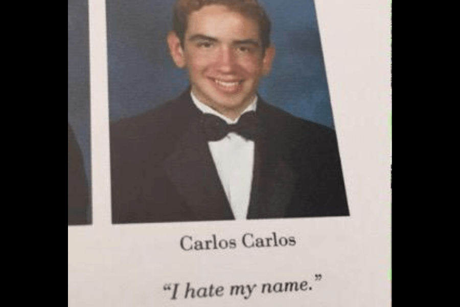 A high school yearbook photo of Carlos Carlos, a young man wearing a black tuxedo and bow tie, smiling at the camera against a blue backdrop. Below his name, his humorous yearbook quote reads, "I hate my name," playfully acknowledging his repetitive name.