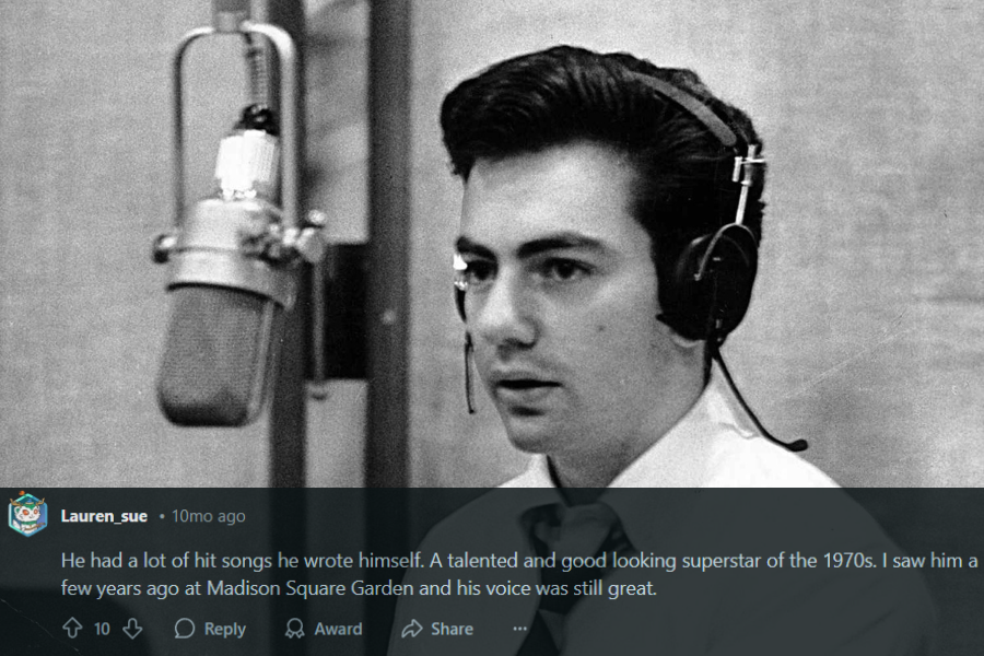 A black and white photograph of a young male singer in a recording studio, wearing headphones and a slightly loosened tie. He looks focused as he sits in front of a vintage microphone, seemingly preparing for a take. The studio's textured walls and classic equipment create a timeless atmosphere.