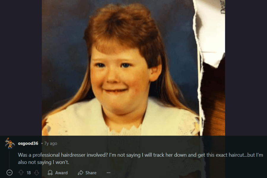  A vintage school portrait of a young girl with a unique 1980s-early 90s hairstyle, featuring short, feathered bangs and long, flowing hair in the back—a subtle mullet variation. She wears a white lace-collared dress and has a cheerful expression. A humorous comment below questions whether a professional hairdresser was involved and jokes about potentially recreating the style.