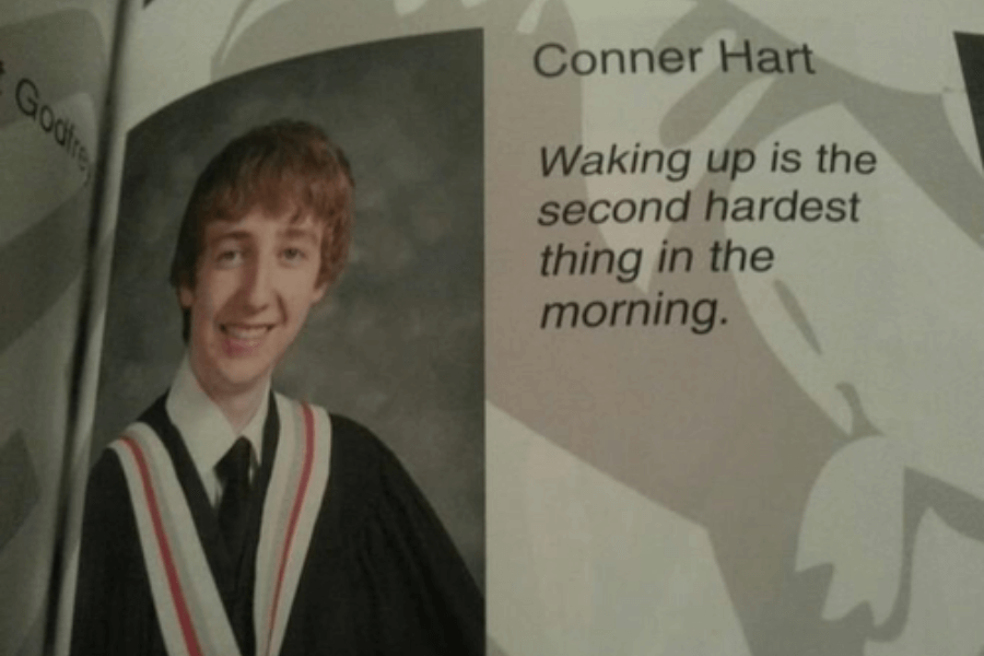 A high school graduation yearbook photo of a young man named Conner Hart, wearing a black graduation gown with a white, red, and black sash, smiling at the camera. His yearbook quote reads, "Waking up is the second hardest thing in the morning," making a bold and suggestive joke.