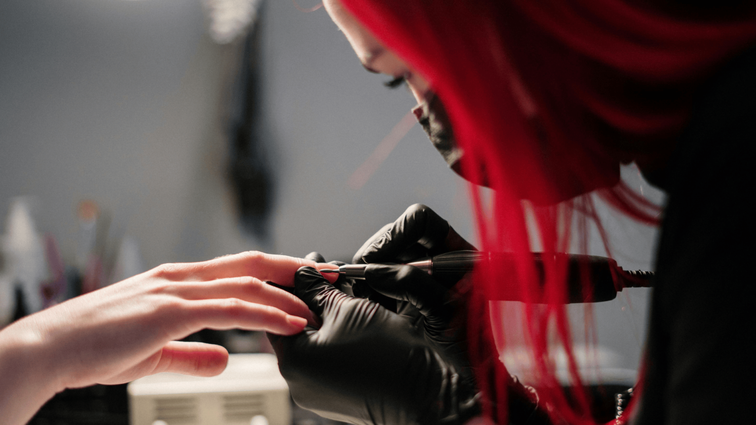 a girl with red hair using a nail gadget