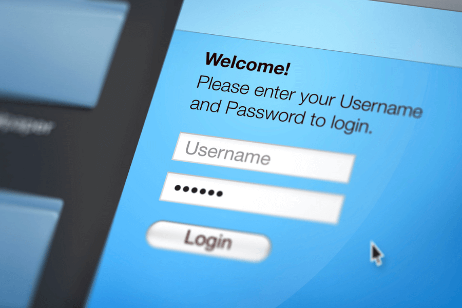 Close-up of a login screen with a blue background, showing fields for username and password, and a welcome message prompting users to enter their credentials to log in. A white mouse cursor is pointed near the "Login" button.