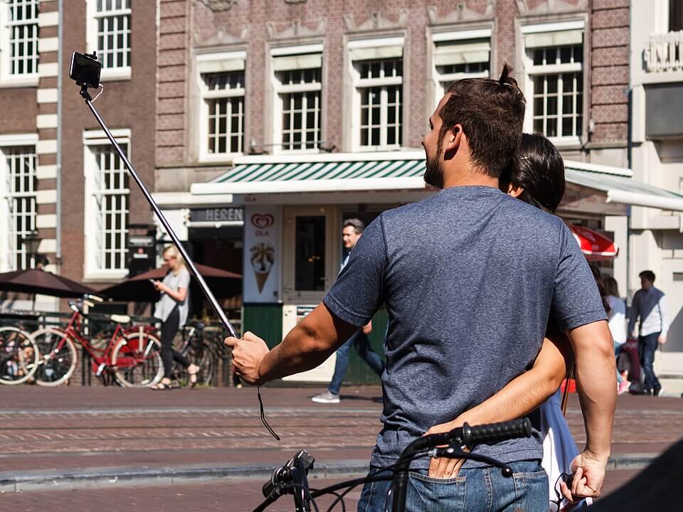 Couple taking a self-portrait using a selfie stick at Konigsluis, Amsterdam, the Netherlands